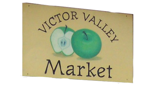 Wooden sign with 'Victor Valley Market' text and two green apples on a white background