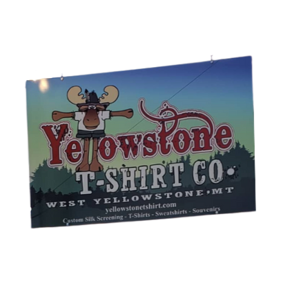 Yellowstone T-Shirt Co. sign with a cartoon moose and scenic background